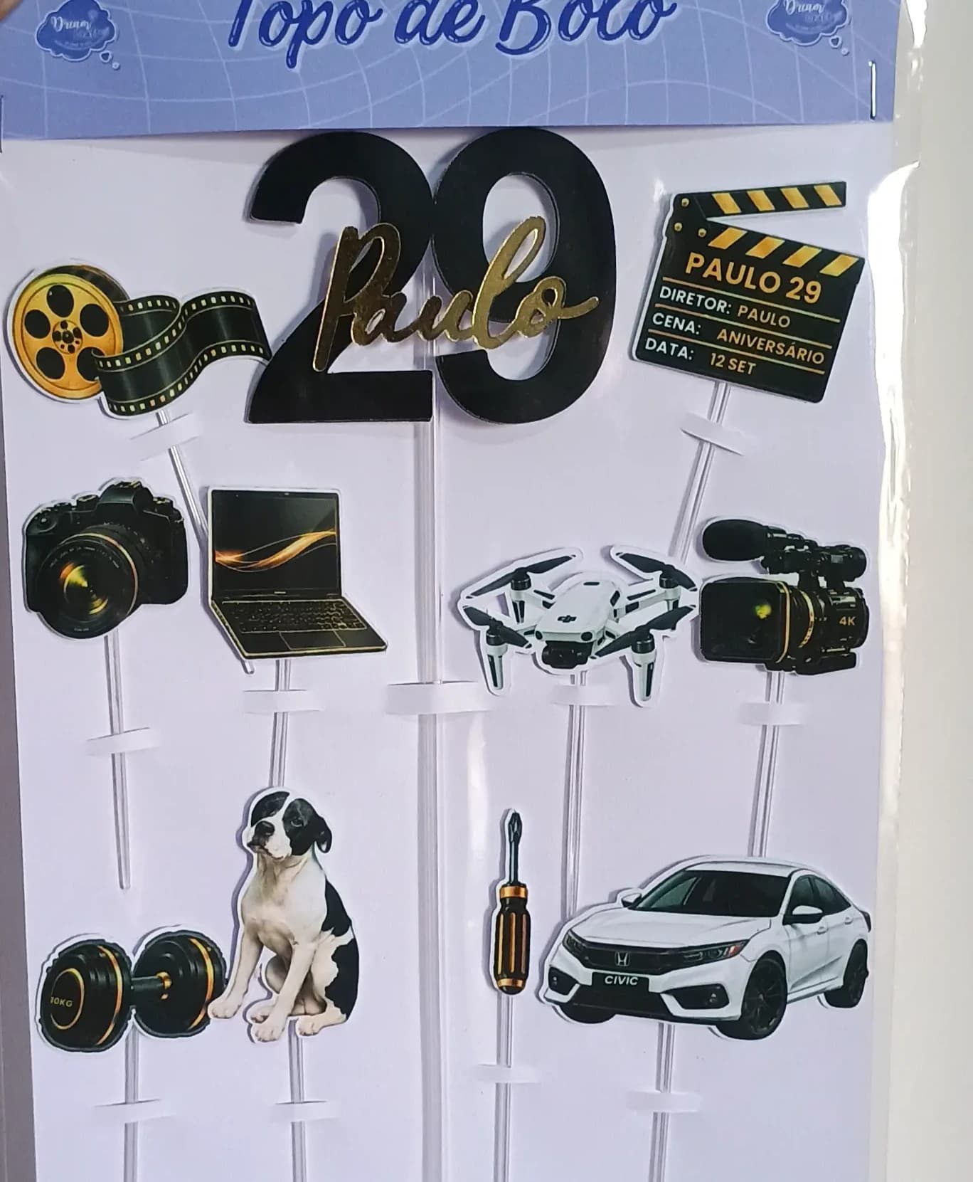 Topo de bolo tema cinema com claquete, rolo de filme e nome em dourado